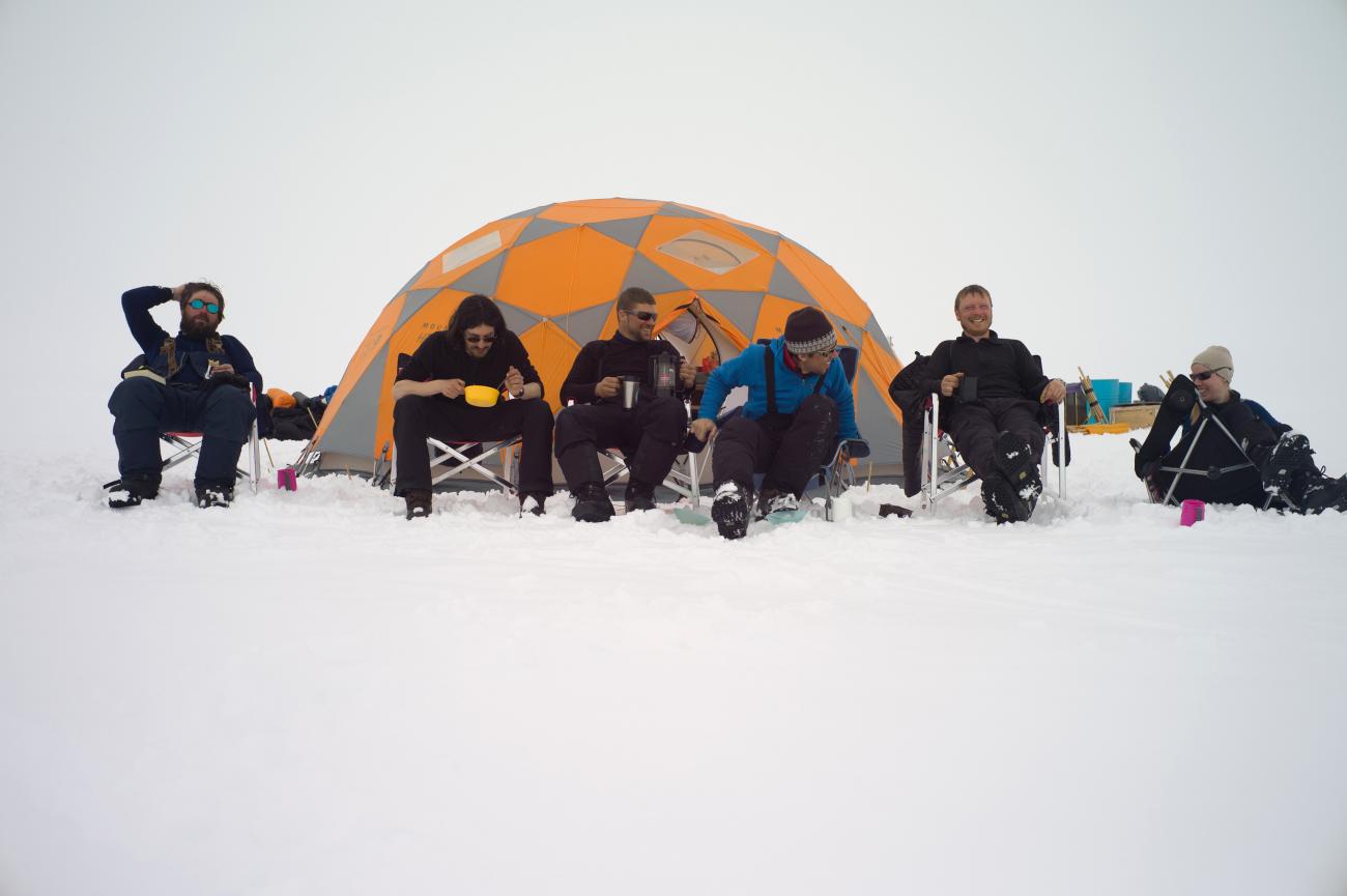 Mike MacFerrin and colleagues awaiting a plane ride on a hot day on the Greenland ice sheet